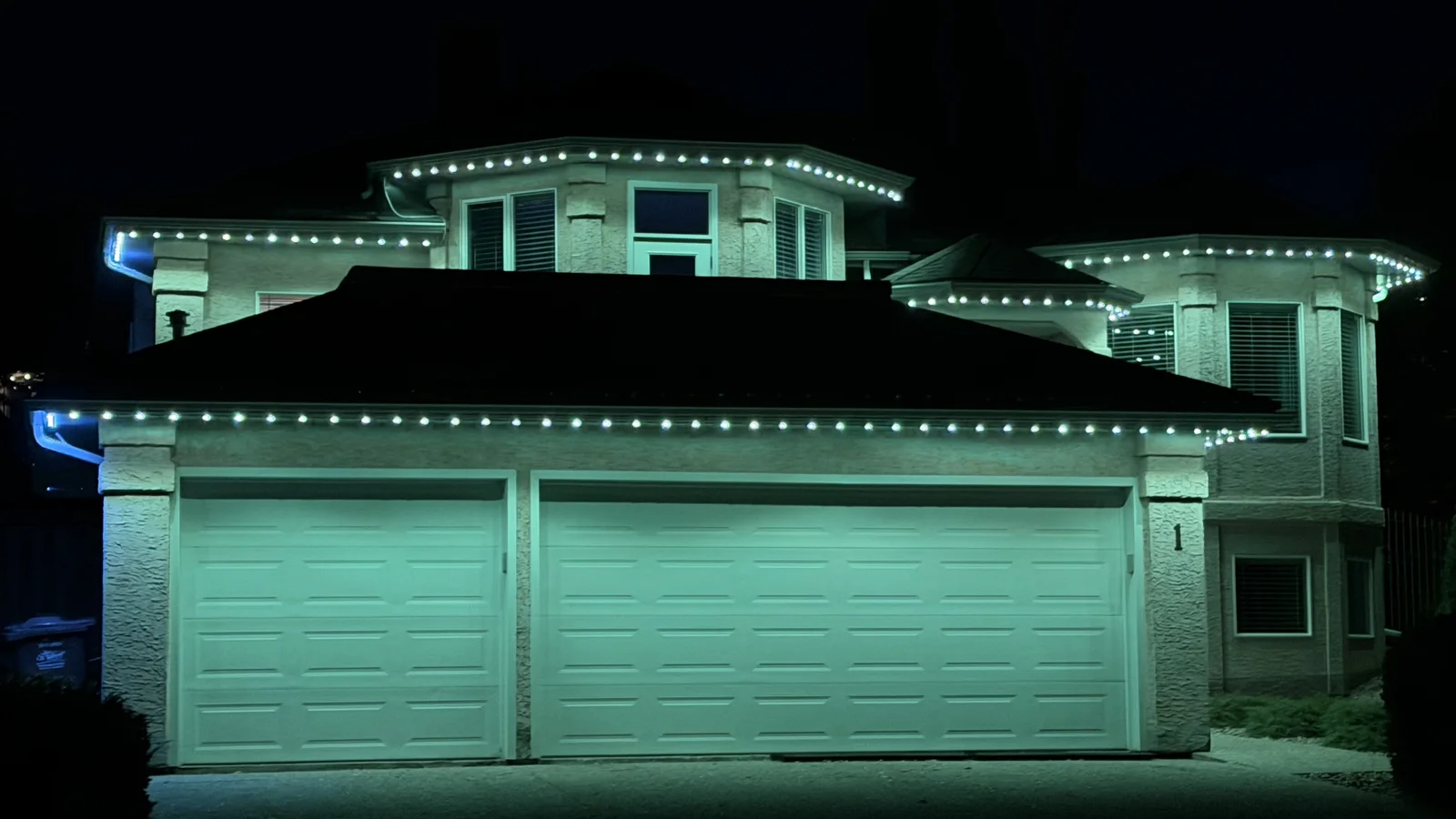 Permanent roofline lights illuminating a Nanaimo home in green and blue
