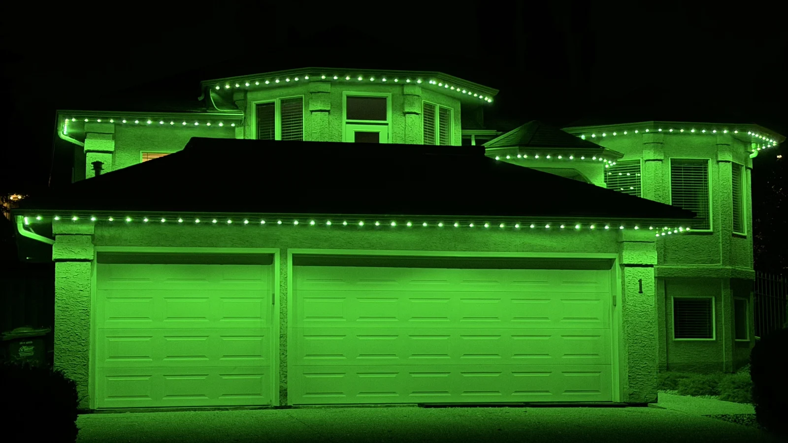 Lime-green permanent lighting across the roofline of a two-storey home