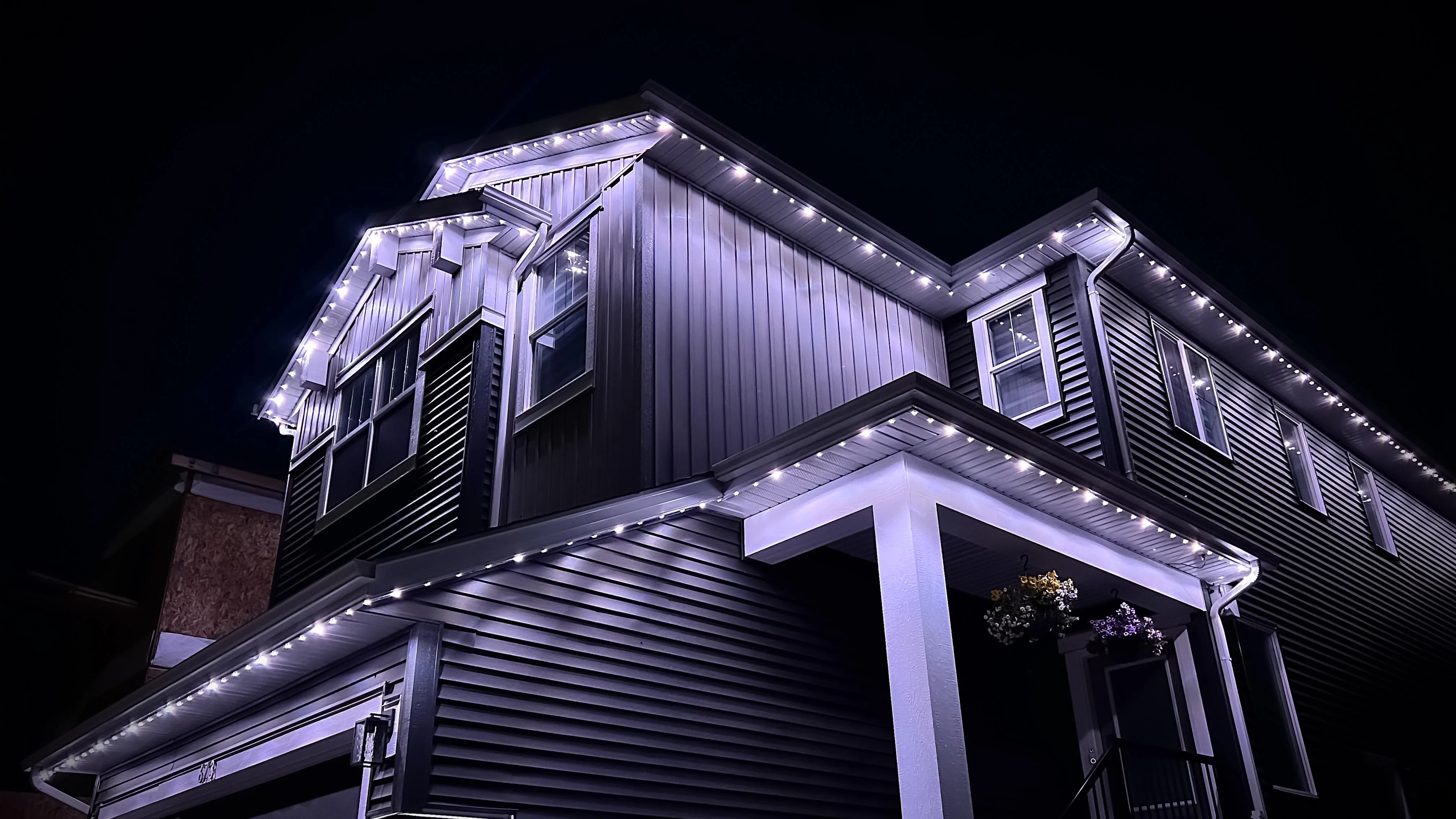 Purple permanent lighting outlining a modern two-storey Nanaimo home